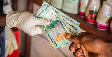 Michael Duff AP Photo of gloved hand handing over Leone currency