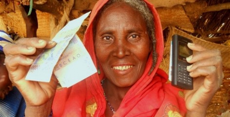 Lady holding cash transfers re-loadable card and a telephone